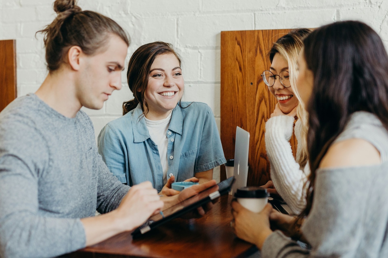 Small group of people gathered around a table, talking